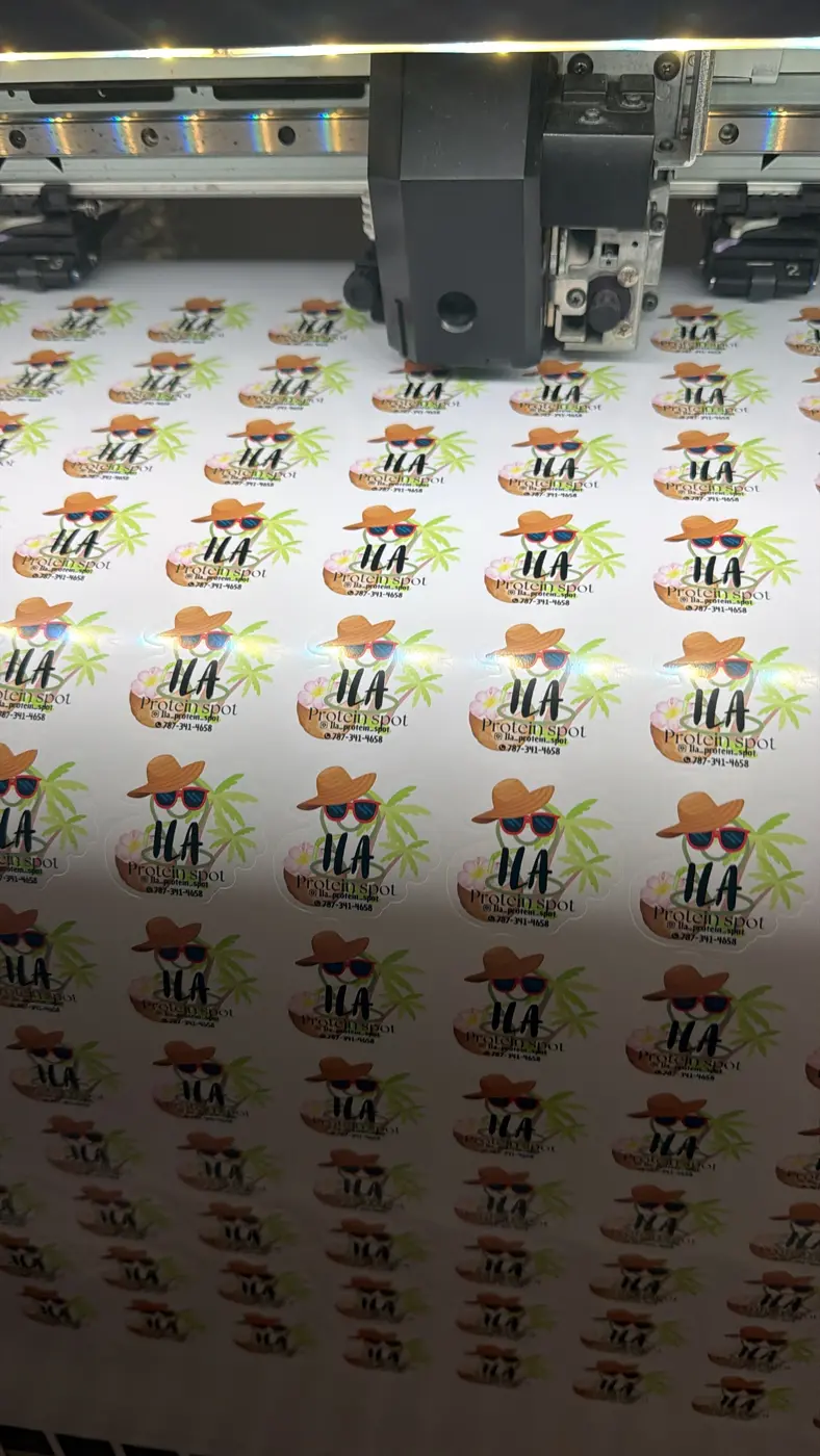 Plotter cortando una tirada de stickers troquelados en el taller